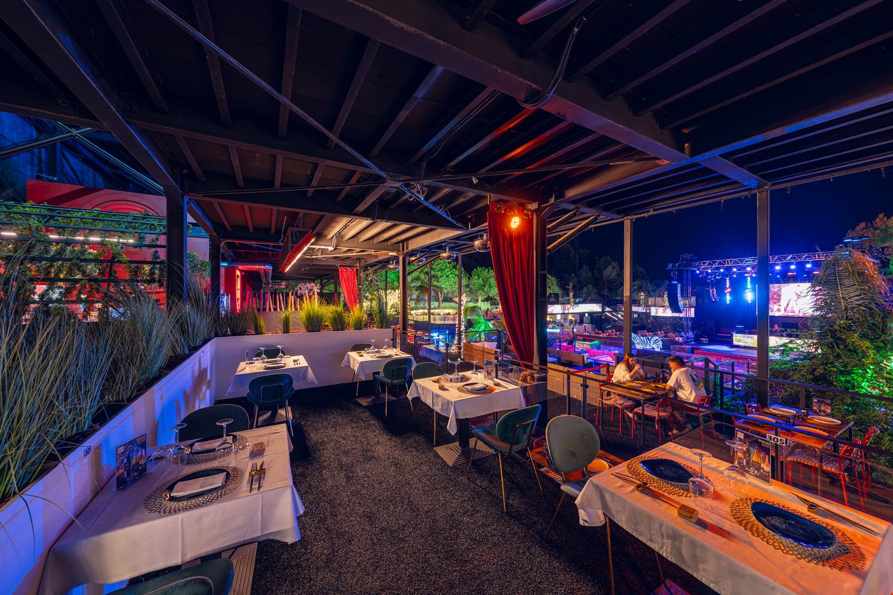 Terraza de Sandra's Bar de noche frente al escenario